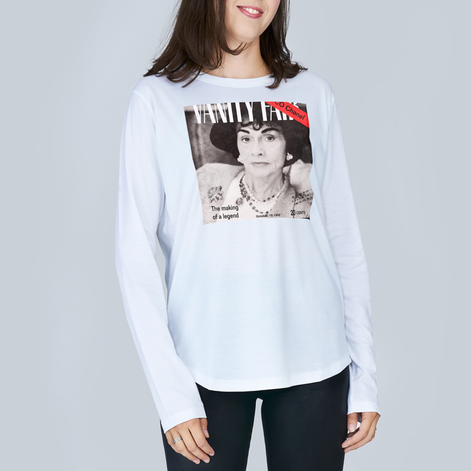 A woman wears The Catherine tee by SUZI ROHER, a slim fit white top with a black-and-white “Vanity Fair” magazine-style graphic of a woman and the text “The making of a legend” on the front.