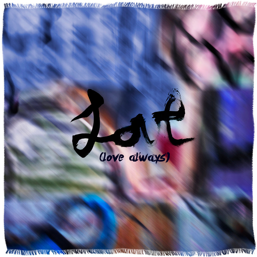 The "Love Always" scarf by SUZI ROHER is a fringed modal silk accessory with a vibrant, blurred background, bold black brushstroke "Lat," and “love always” in smaller black script beneath.