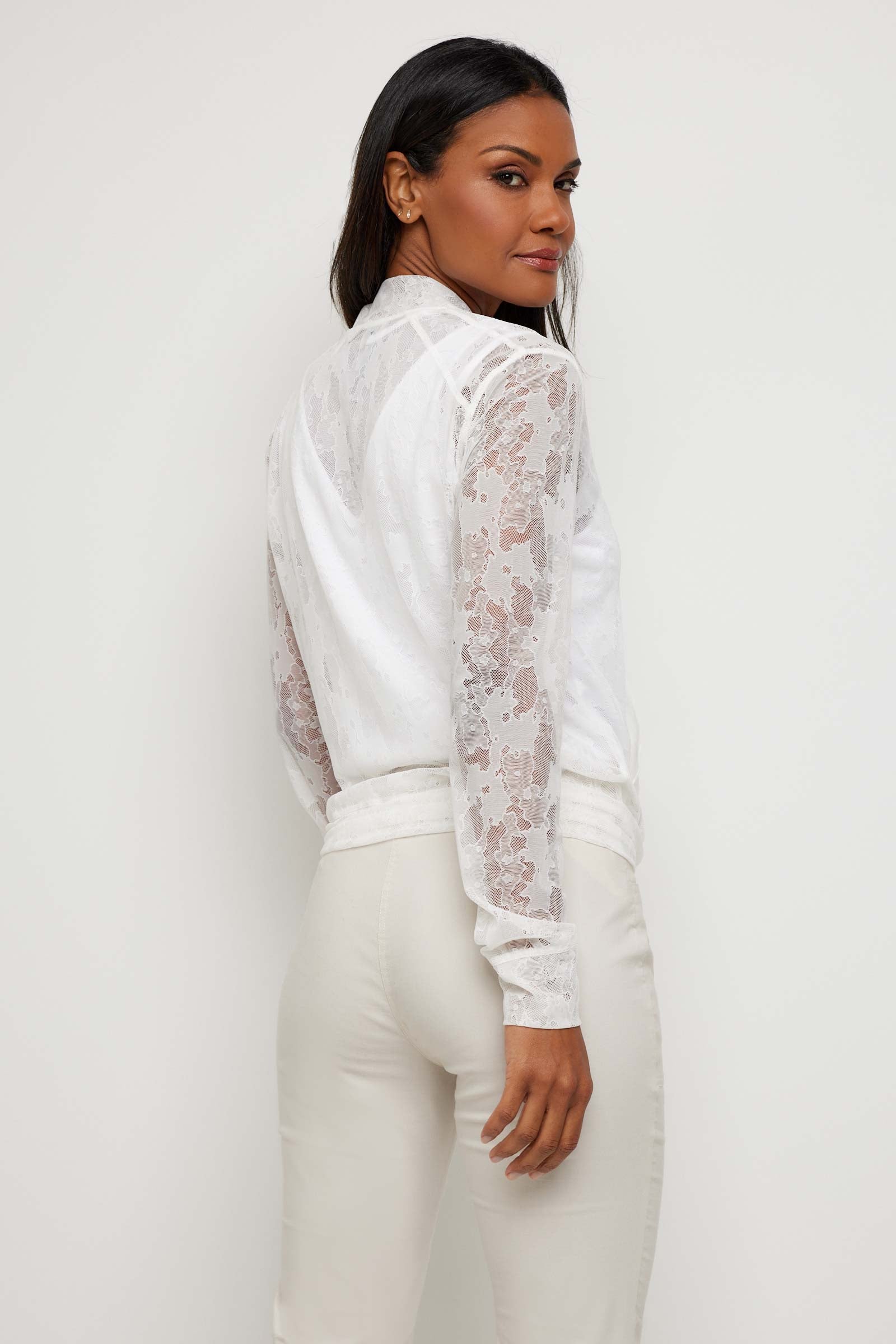 The Best Travel Jacket. Woman Showing the Back Profile of a Bailey Camo Mesh Jacket in White.