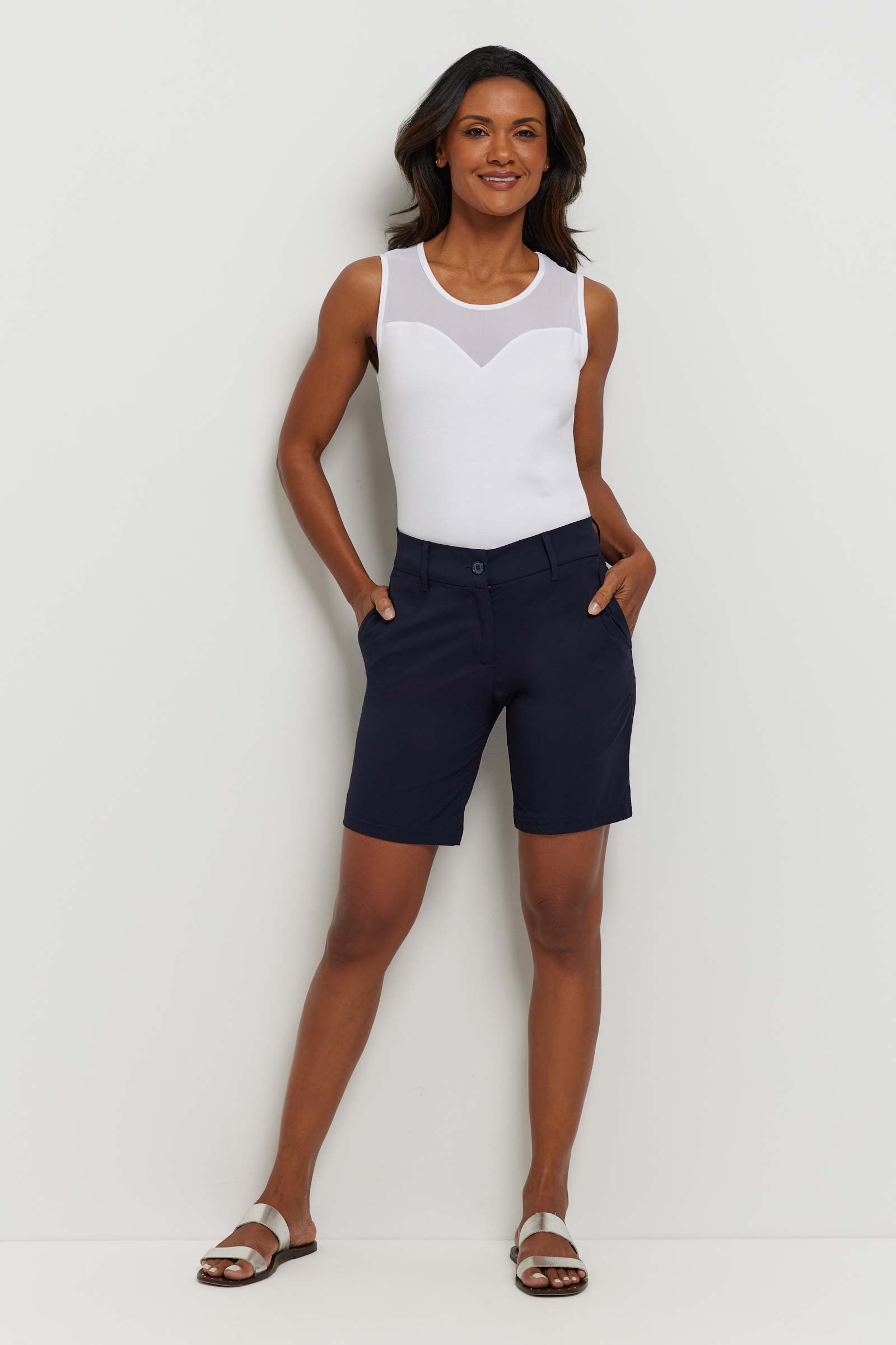 The Best Travel Short. Woman Showing the Front Profile of a Breck Performance Cotton Short in Navy.