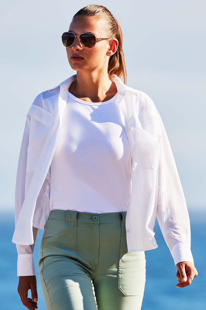 The Best Travel Top. Lifestyle Image of Woman Showing the Front Profile of a Kieran Top in White.