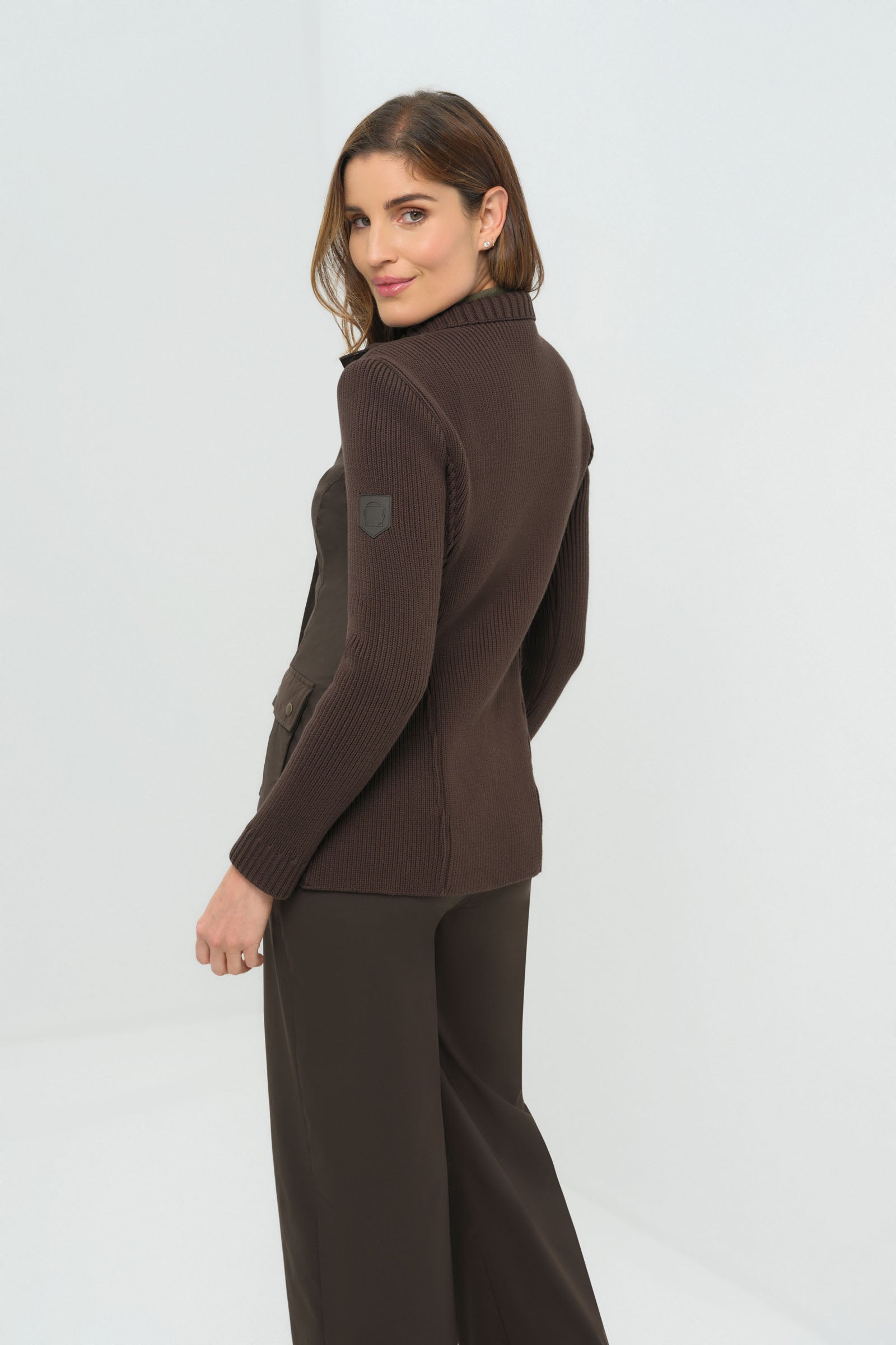 Front view of olive green jacket featuring  knitted back and side.