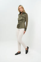 Front view of olive green button-up with collar, paired with white straight-leg pants.
