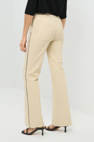 Back view of wheat pants with a black stripe on the side and a pocket.