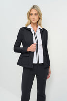 A slim-fit black jacket, open in the front, paired with a crisp white collared shirt and tailored black pants for a sleek, modern look.