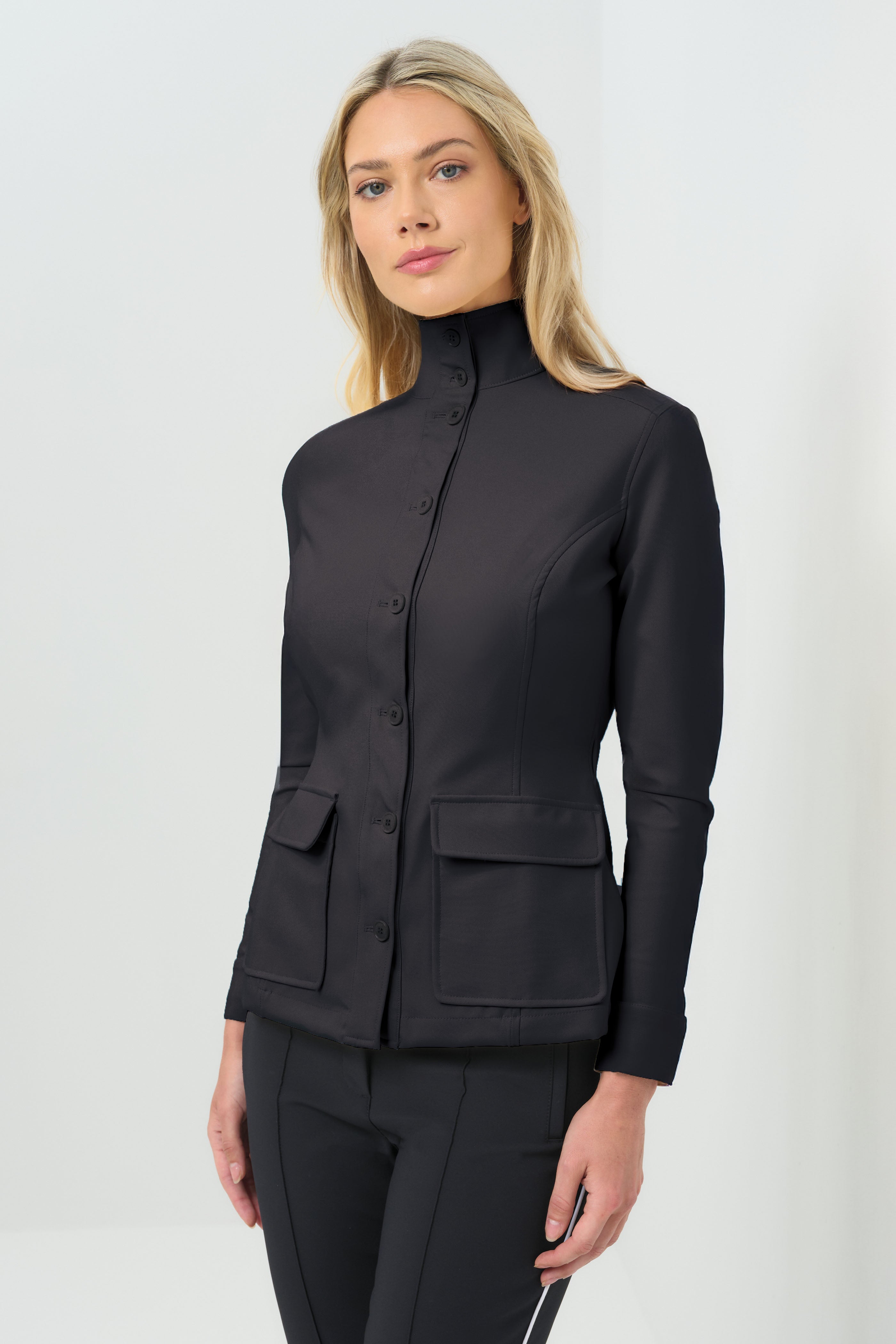 Black button-up jacket fastened to the neck, paired with slim black pants for a sharp, streamlined silhouette.