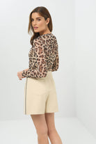 Side view of a skort with a black side stripe, paired with a cheetah-print long-sleeve top.