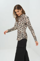 Side view cheetah-print button-down blouse with a classic collar and long sleeves, paired with black utility-style cargo pants featuring flap pockets.