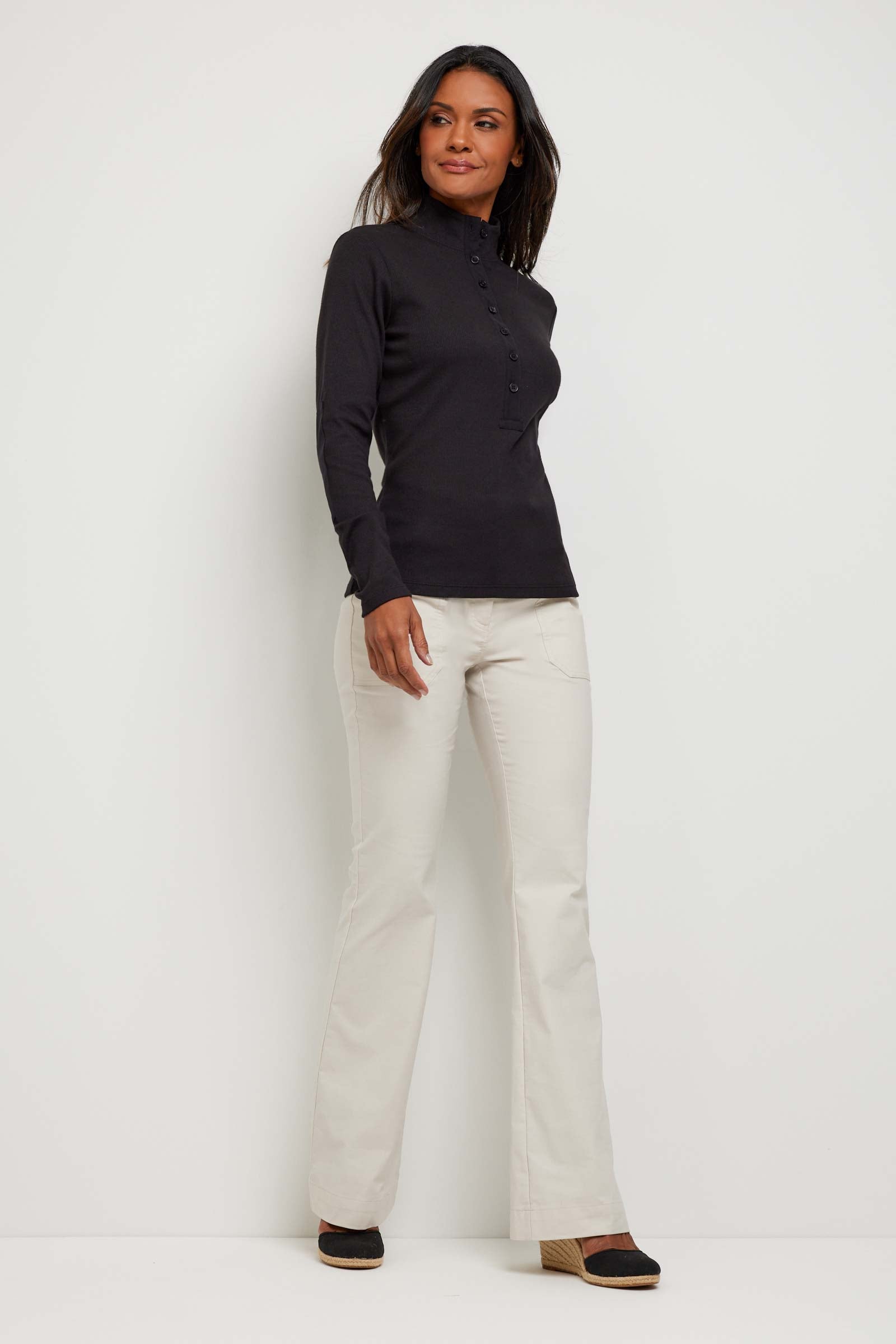 The Best Travel Top. Woman Showing the Front Profile of a Monroe Henley Top in Black.