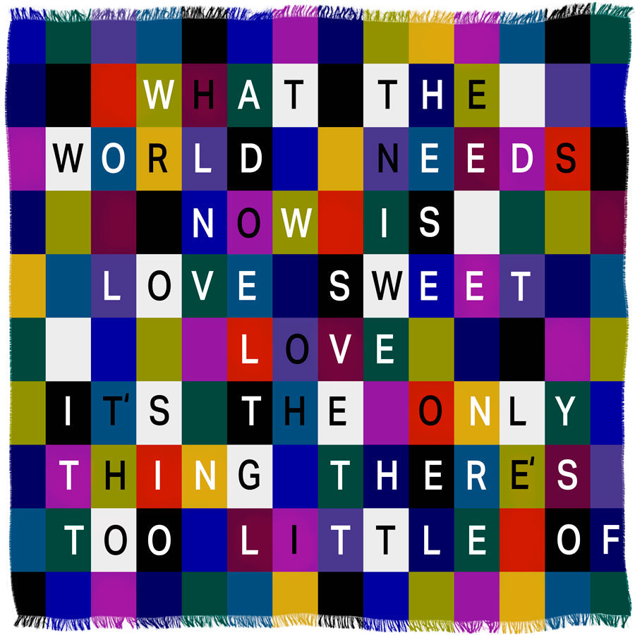 The “Sweet Love” scarf by SUZI ROHER features a vibrant grid design, each square displaying a letter from the iconic phrase: WHAT THE WORLD NEEDS NOW IS LOVE SWEET LOVE.