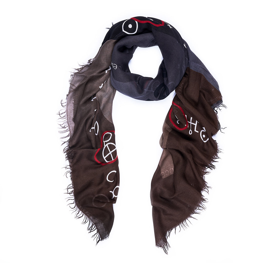 The SUZI ROHER Planets-naturals scarf is lightweight with frayed edges, featuring a dark brown to black gradient and abstract white and red symbols, resembling a celestial tapestry. Shown in a loose loop on a white background.
