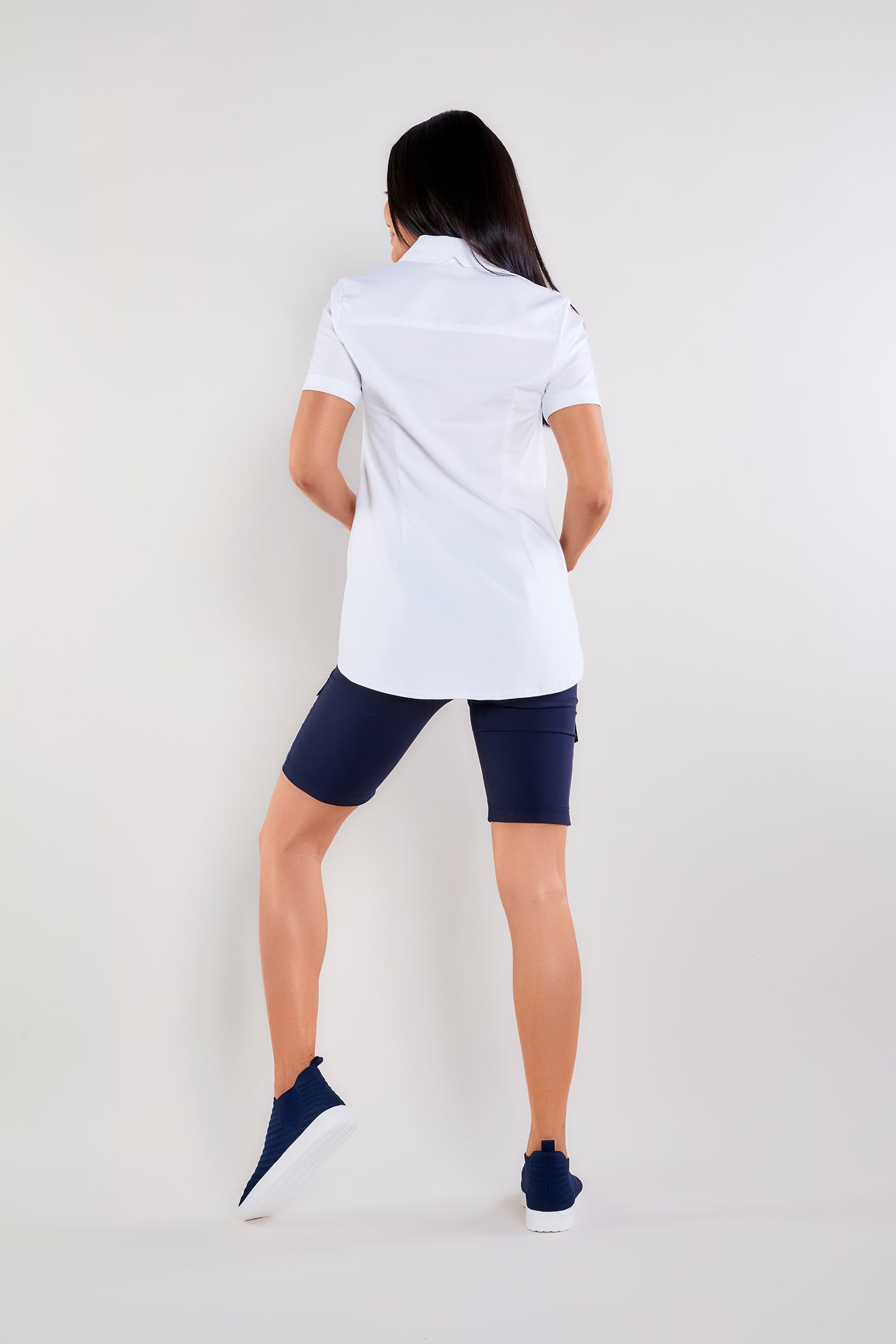 The Best Travel Top. Woman Showing the Back Profile of a Helia Top in White.