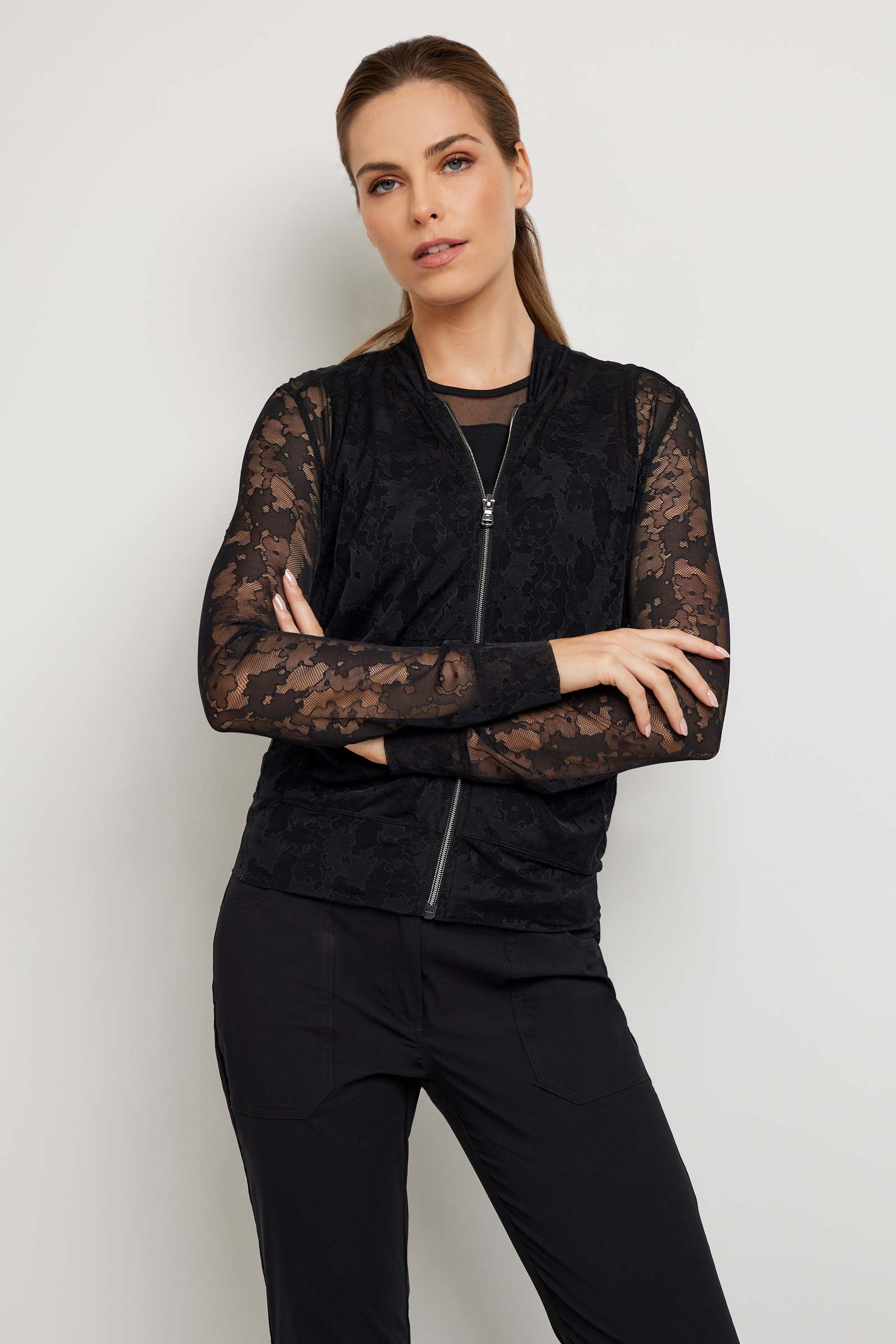 The Best Travel Jacket. Woman Showing the Front Profile of a Bailey Camo Mesh Jacket in Black.