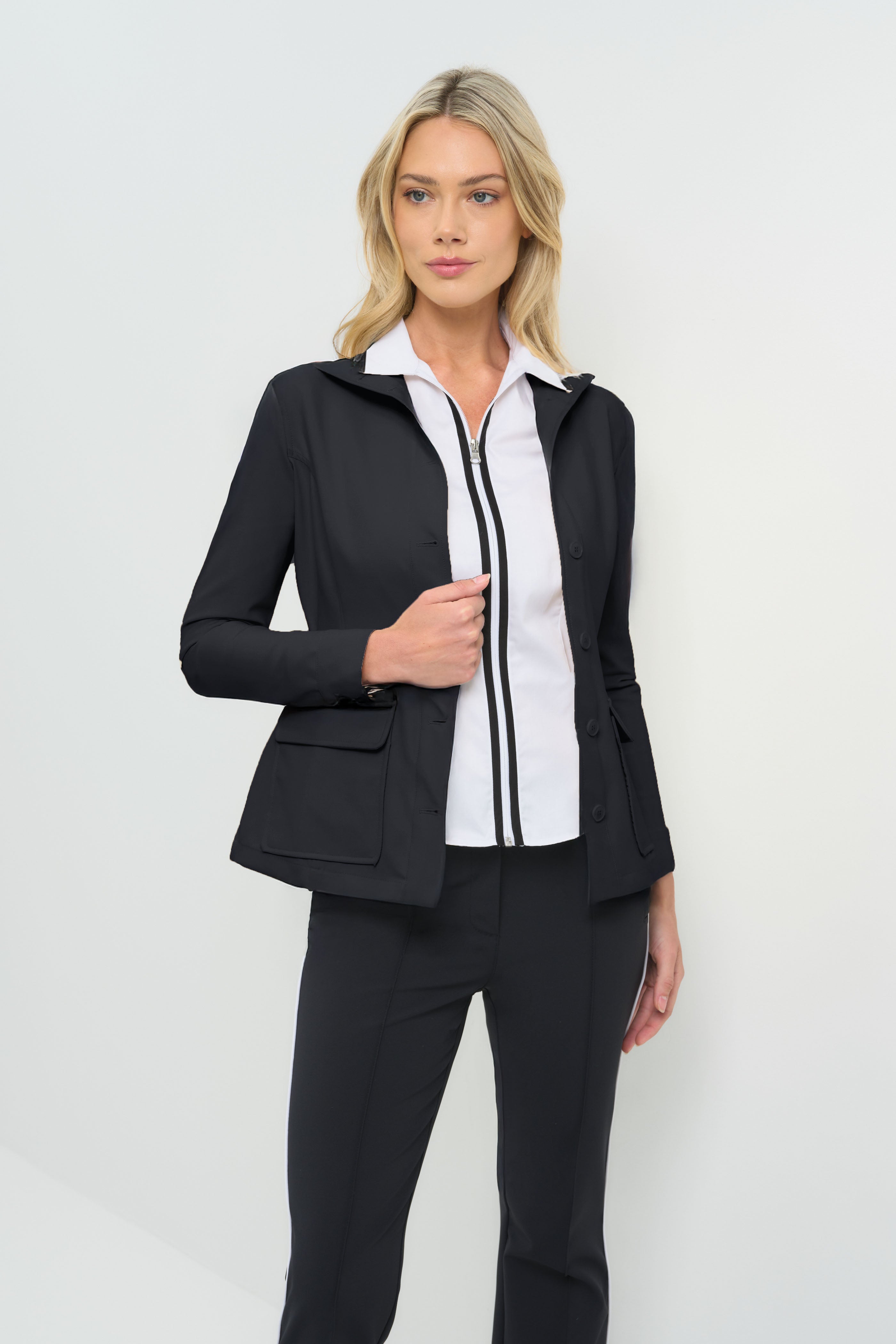A slim-fit black jacket, open in the front, paired with a crisp white collared shirt and tailored black pants for a sleek, modern look.