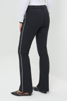 Back view black high-waisted tailored pants featuring a slim fit through the thigh and a subtle flare at the hem. Designed with clean front seams and accented by contrast side stripes for a modern, elongating effect.