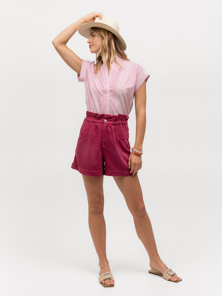 Woman in a hat wearing a pink and white polka dotted shirt