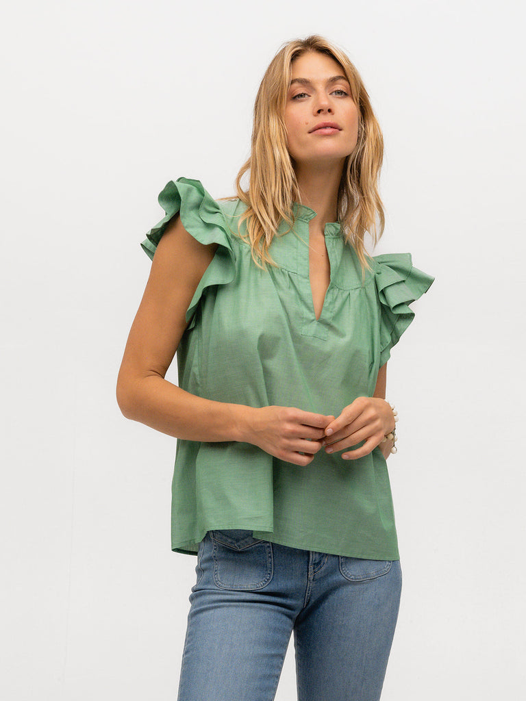 Model wearing a green ruffled sleeve shirt