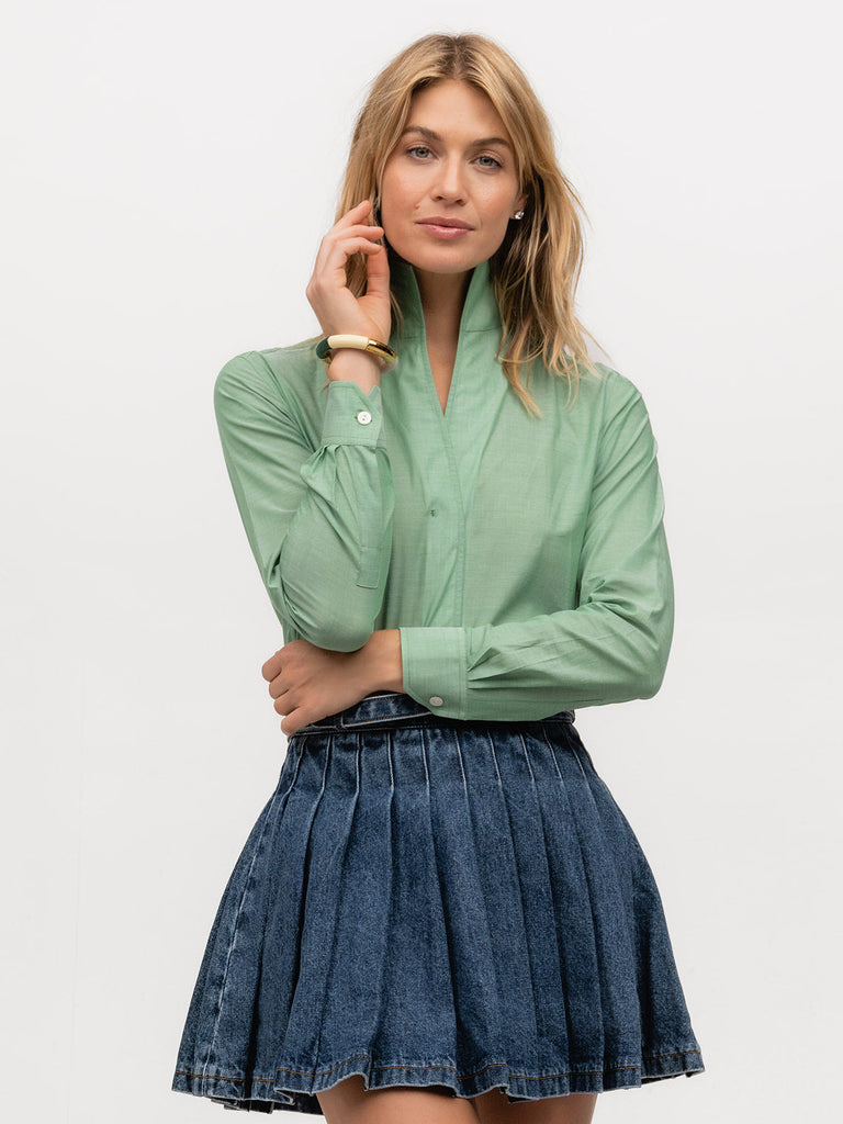 A feminine lady wearing a long sleeve dress shirt in a light green fabric