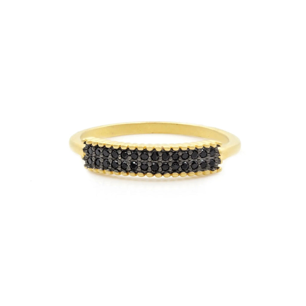 The Pavé Thin Marquee Ring by FREIDA ROTHMAN is a 14K gold piece characterized by a horizontal band of small black diamonds set on the top. Its slim band and closely spaced diamonds create a neat row, delivering a sleek and elegant appearance. This sophisticated ring is photographed against a plain white background.