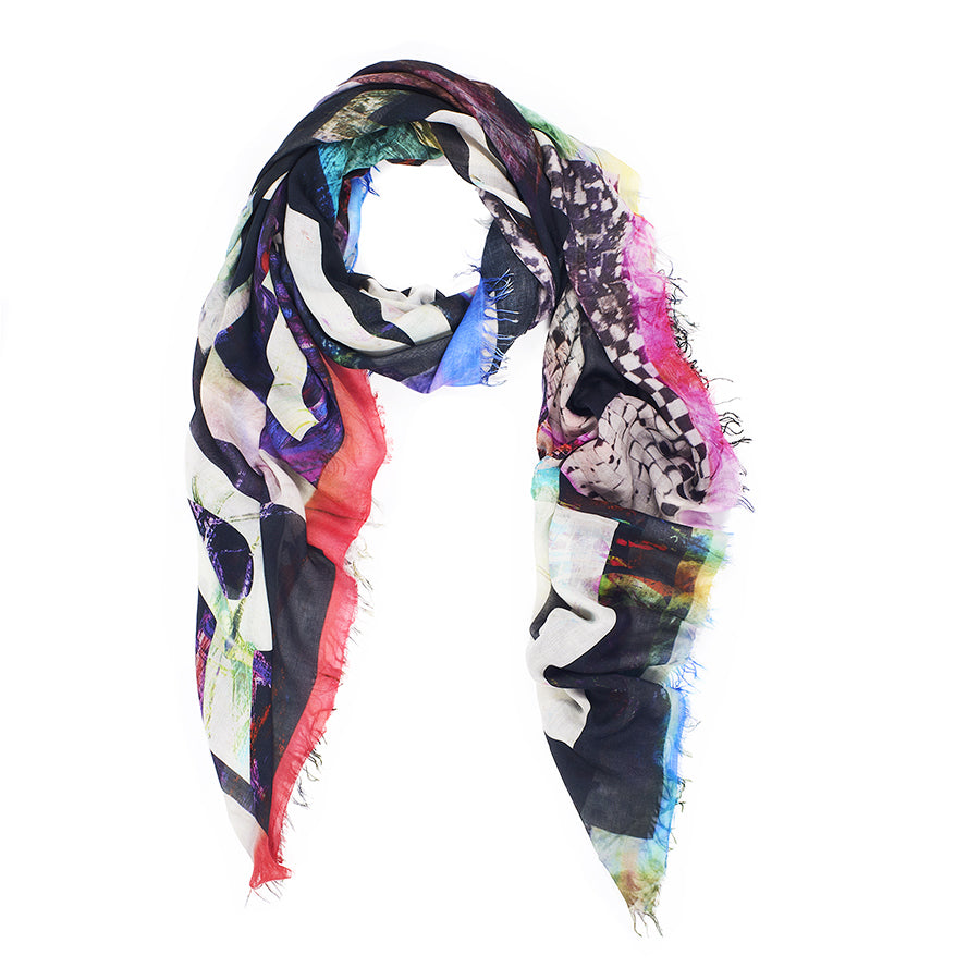 The SUZI ROHER "Make Art Not War" scarf is a lightweight modal silk accessory featuring abstract patterns, black and white stripes, vibrant splashes of blue, pink, red, and yellow, frayed edges, loosely draped in a loop. Made in Italy.