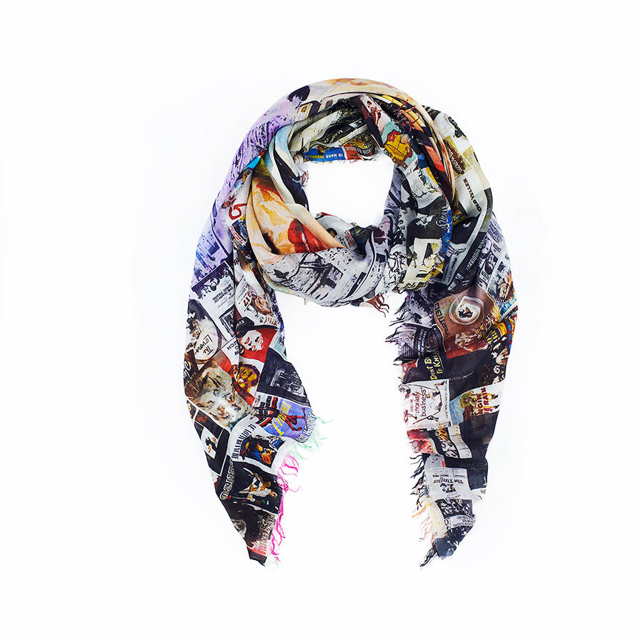 The Marlene Dietrich scarf by SUZI ROHER is a lightweight accessory with frayed edges, showcasing a vibrant collage of images, text, and patterns on a white background.