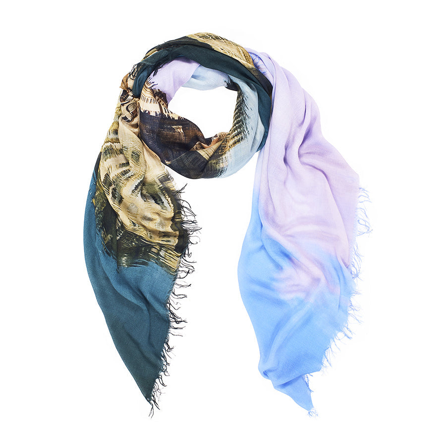 The SUZI ROHER Campari Time scarf is lightweight with frayed edges, showcasing a gradient in dark green, gold, lavender, and light blue. Loosely draped in a circle, it's inspired by the colors of an Italian aperitif and made in Italy.