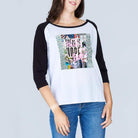 A woman wears The Bailey tee by SUZI ROHER—100% cotton, boxy cut, featuring a colorful “There is Hope” graphic and text on the front—paired with blue jeans against a plain light gray background.