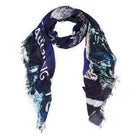 The SUZI ROHER Madame Fortuna Vol 2 scarf is a dark, rectangular modal silk piece with frayed edges, abstract patterns, text like "Love Fate and Destiny," and hues of navy blue, green, white, and black, styled in a loose loop.