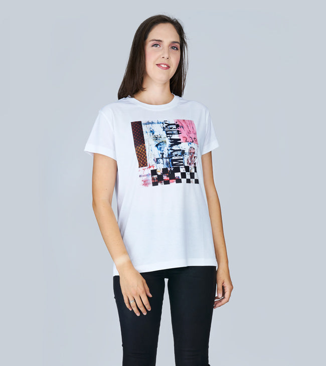 A woman with long brown hair models SUZI ROHER's "The Niki" white graphic t-shirt, inspired by Frank Sinatra's "My Way," paired with black skinny jeans against a light gray background.