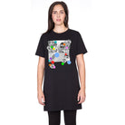 A woman with long brown hair wears the oversized SUZI ROHER "Daisy, Because We love You" black T-shirt dress with a black-and-white collage and colorful dots on the front, standing facing the camera against a white background.