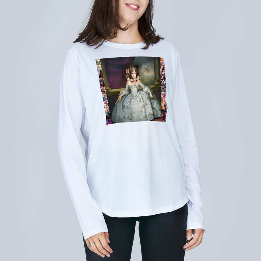 A woman with brown hair wears The Catherine by SUZI ROHER, a white slim-fit 100% cotton long-sleeve crew neck tee featuring a printed image of a historical woman in an elaborate gown, set against a plain light gray background.