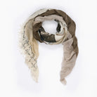 The SUZI ROHER "Ginger" scarf features light and dark brown silk with frayed edges, faint handwritten-style white text, and a loosely draped design that channels effortless elegance.