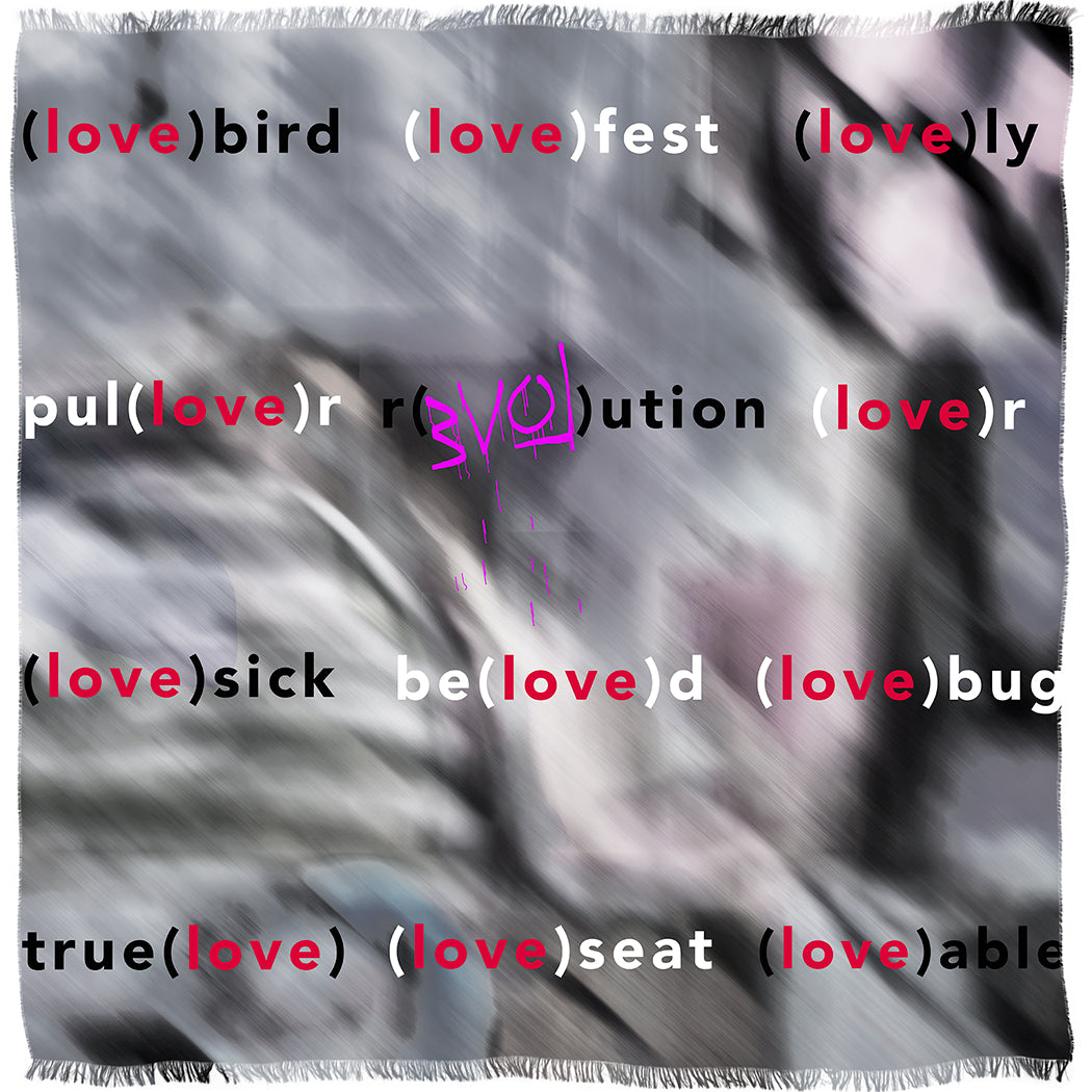 A blurred, abstract background with words like “(love)bird” and “revo(love)ution” embodies the spirit of love on SUZI ROHER’s Lovefest modal silk scarf, artfully crafted in Italy.
