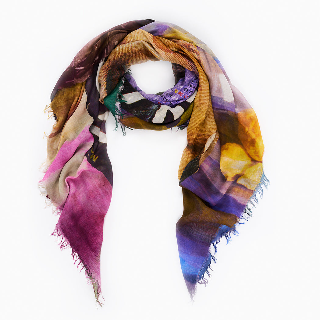 Romance by SUZI ROHER: an Italian-made, lightweight rectangular modal silk scarf with a colorful abstract pattern in pink, purple, yellow, blue, and brown. Features slightly frayed edges and comes loosely twisted in a circular shape.