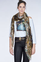 A woman with dark hair in a bun wears The Bailey boxy cut tee by SUZI ROHER, featuring a print of a woman in a blue gown, styled with black leather pants and accessories, evoking vintage Greta Garbo against a light background.