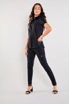 The Best Travel Top. Woman Showing the Side Profile of a Helia Top in Black.